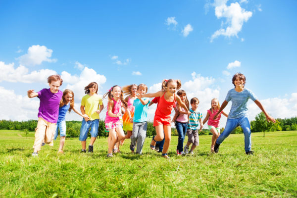Many kids running Large group of kids, friends boys and girls running in the park on sunny summer day in casual clothes